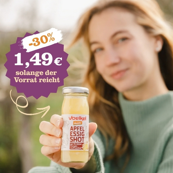 KI generiert: Eine Frau hält einen Apfelessigshot, Angebot: 1,49€, 30% Rabatt, solange der Vorrat reicht.