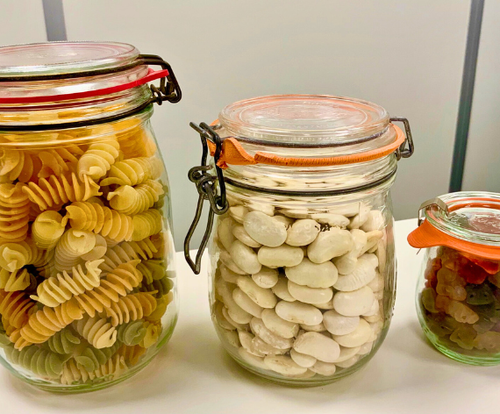 KI generiert: Drei Einmachgläser mit Nudeln, Bohnen und getrockneten Tomaten auf einem Tisch.
