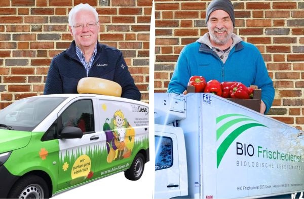 KI generiert: Zwei Männer mit Lieferwagen vor einer Backsteinwand, ein Wagen hat einen Käse, der andere rote Paprika.