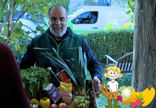 KI generiert: Ein Mann liefert eine Kiste mit frischem Obst und Gemüse aus. Text auf Kleidung und Auto: "Biokiste".