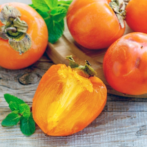 KI generiert: Kakis und Minzblätter dekorativ arrangiert auf einem Holzbrett.